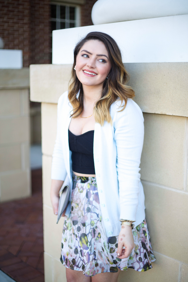 Mae Amor- floral Asher by Fab'rik skirt, black bandage crop top, light blue cardigan, Rebecca Minkoff Leo clutch, black ankle strap heels, Loren Hope