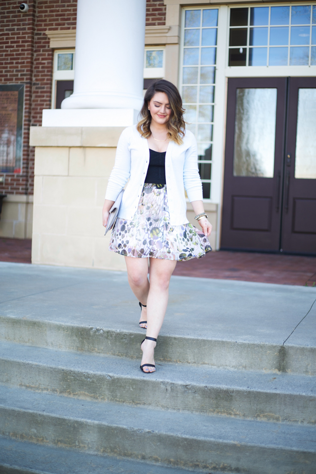 Mae Amor- floral Asher by Fab'rik skirt, black bandage crop top, light blue cardigan, Rebecca Minkoff Leo clutch, black ankle strap heels, Loren Hope