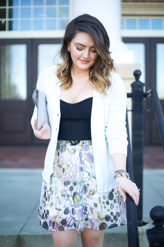 Mae Amor- floral Asher by Fab'rik skirt, black bandage crop top, light blue cardigan, Rebecca Minkoff Leo clutch, black ankle strap heels, Loren Hope